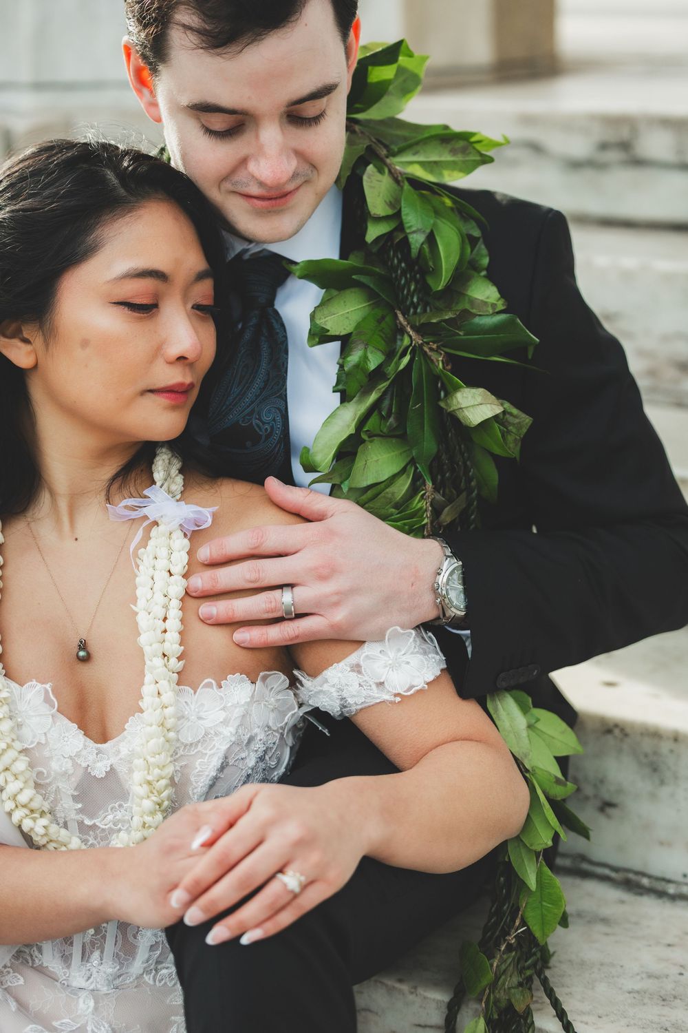 Bride and groom in wedding attire with Hawaiian leis, sitting together in a romantic pose for washington dc wedding photography