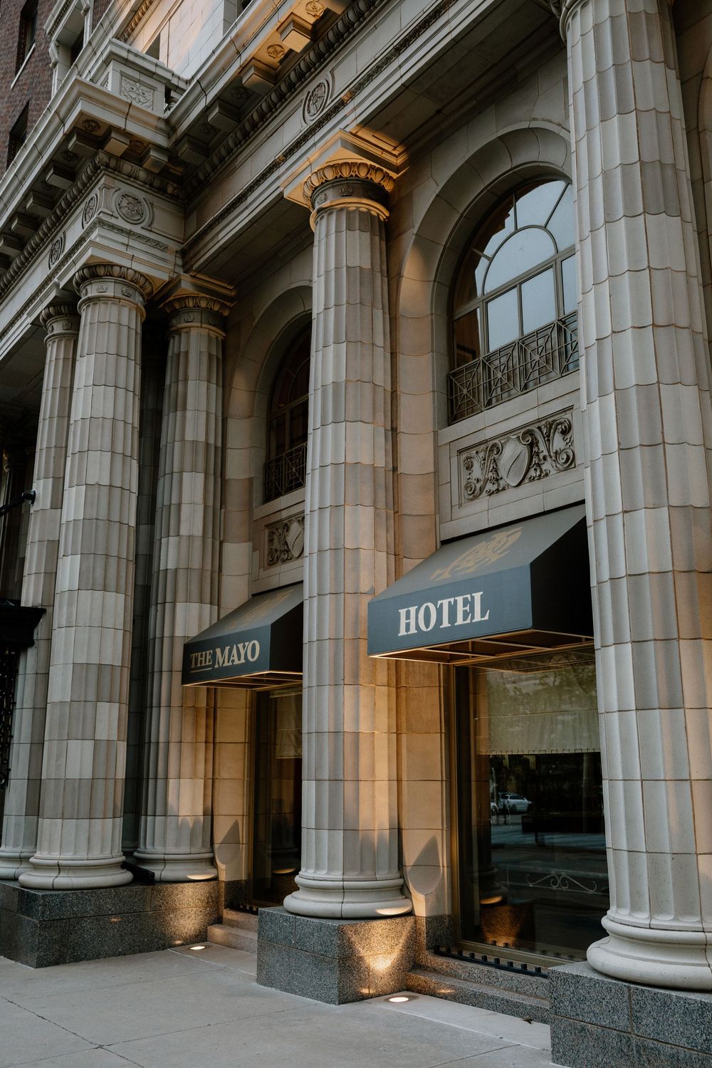 The Mayo Hotel entrance featuring grand stone columns and elegant arched windows in Tulsa, Oklahoma.