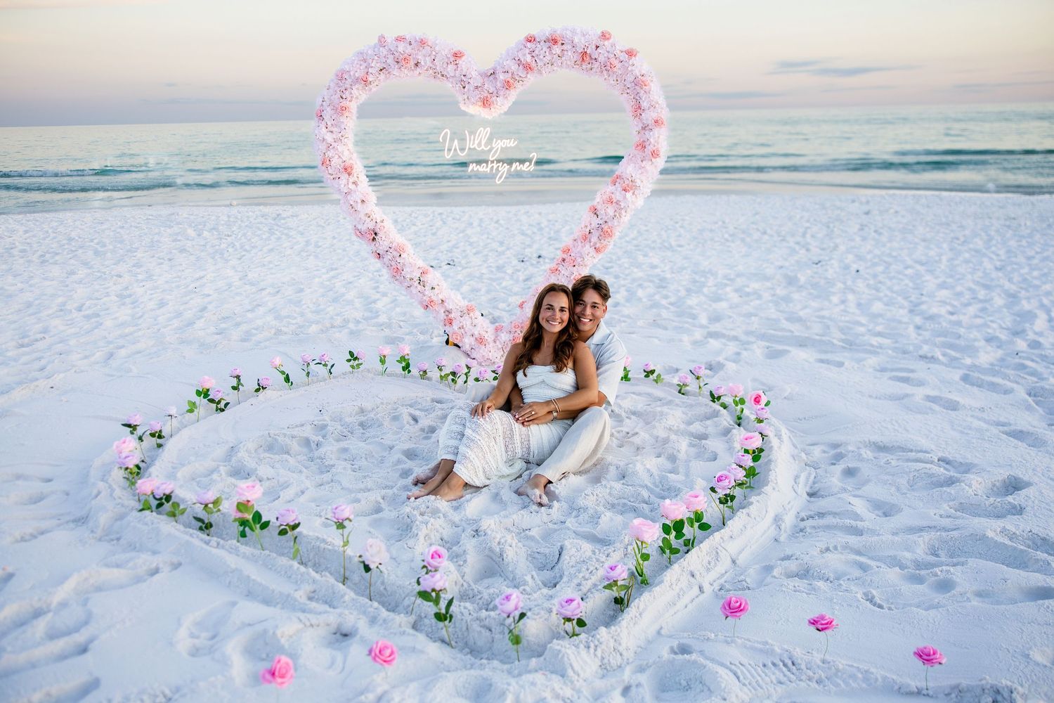 newly engaged couple cuddling on a emerald coast beach