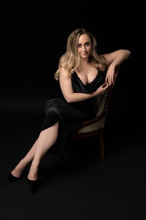 Elegant seated woman portrait with dramatic studio lighting near Glasgow.
