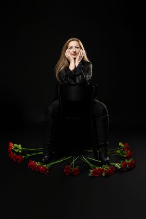 Editorial style women's portrait in an elegant black dress photographed in a studio.
