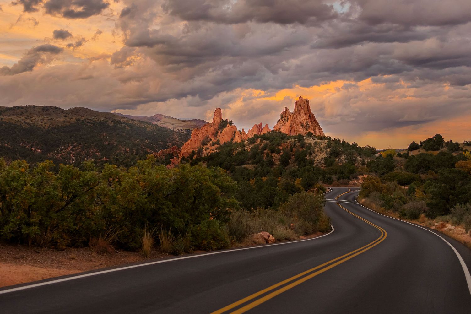 garden of the gods maternity photoshoot at sunset with tall rocky formations and mountain backdrop