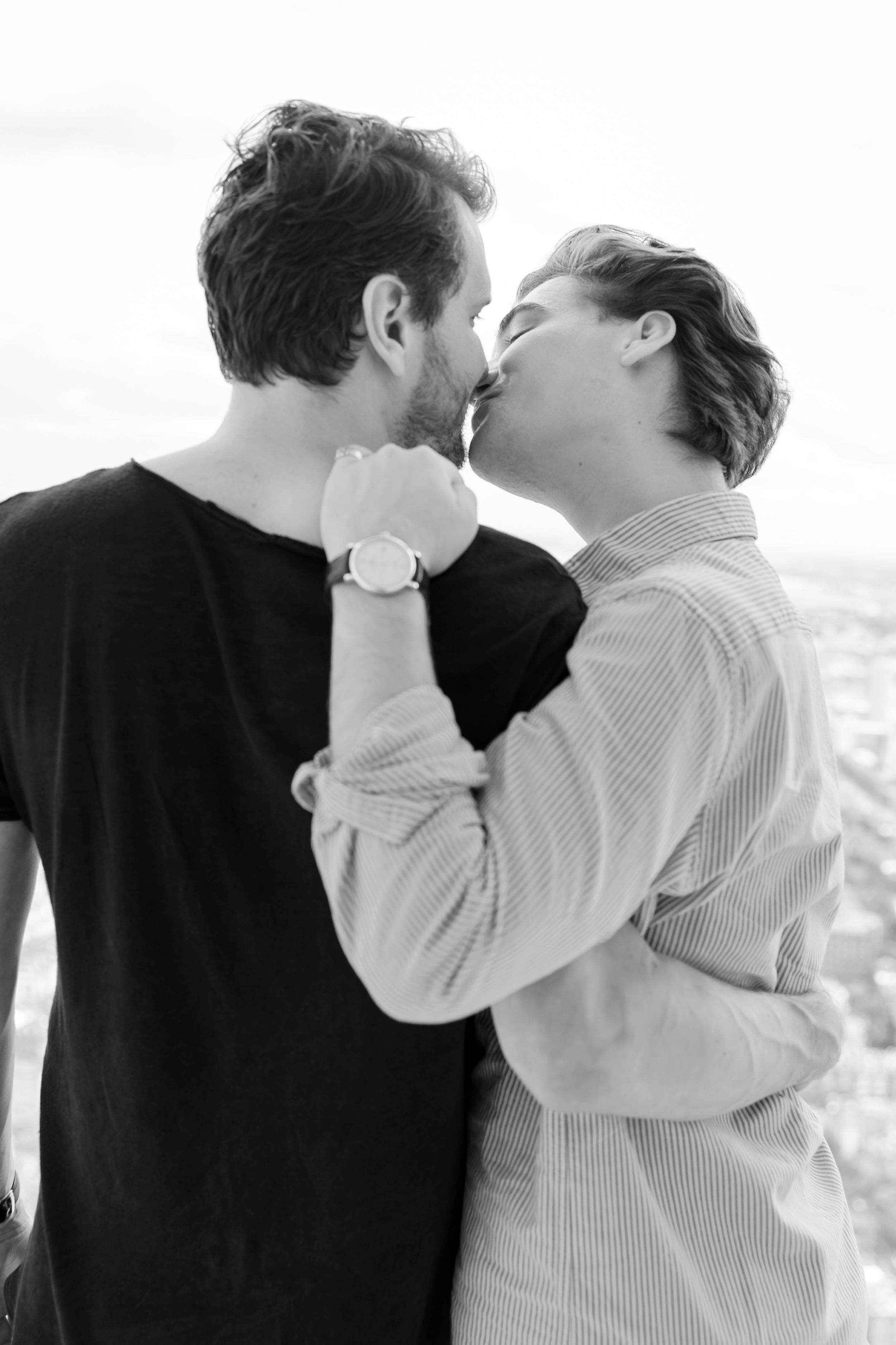 Black and white intimate portrait series showing tender embrace against white backdrop.
