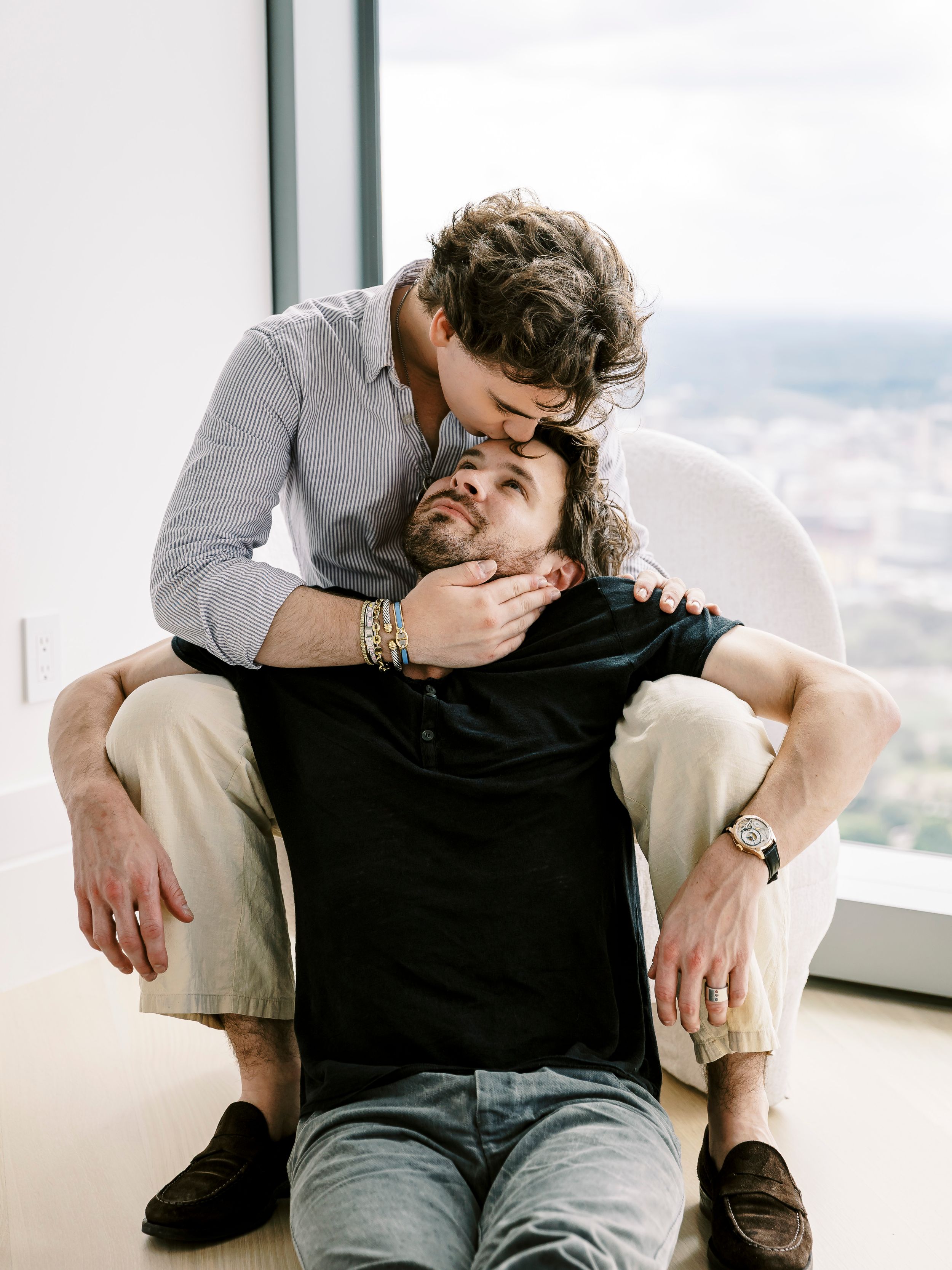 Casual lifestyle photoshoot with people relaxing in modern high-rise apartment.
