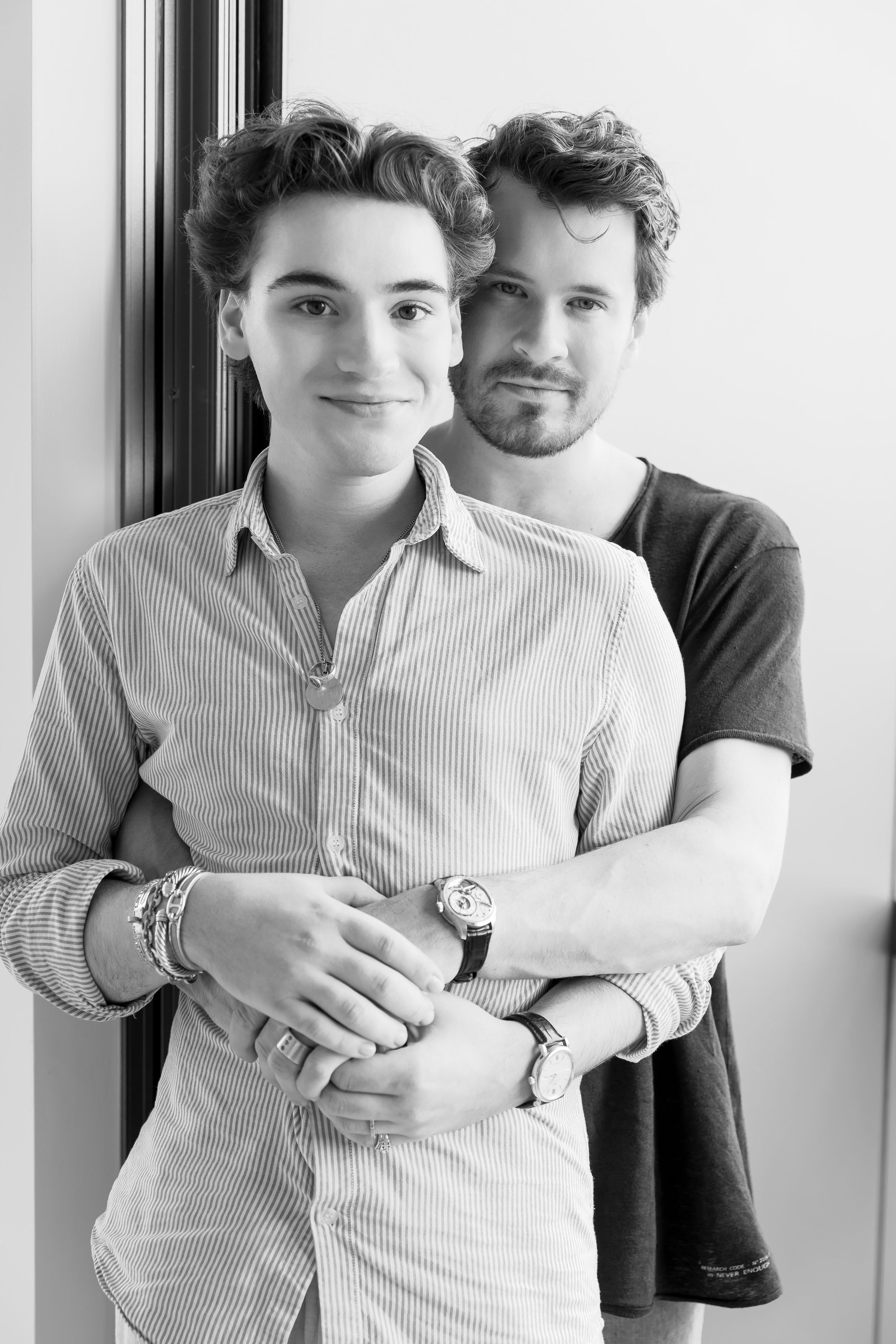 Black and white portrait series showing affectionate embrace in white interior.