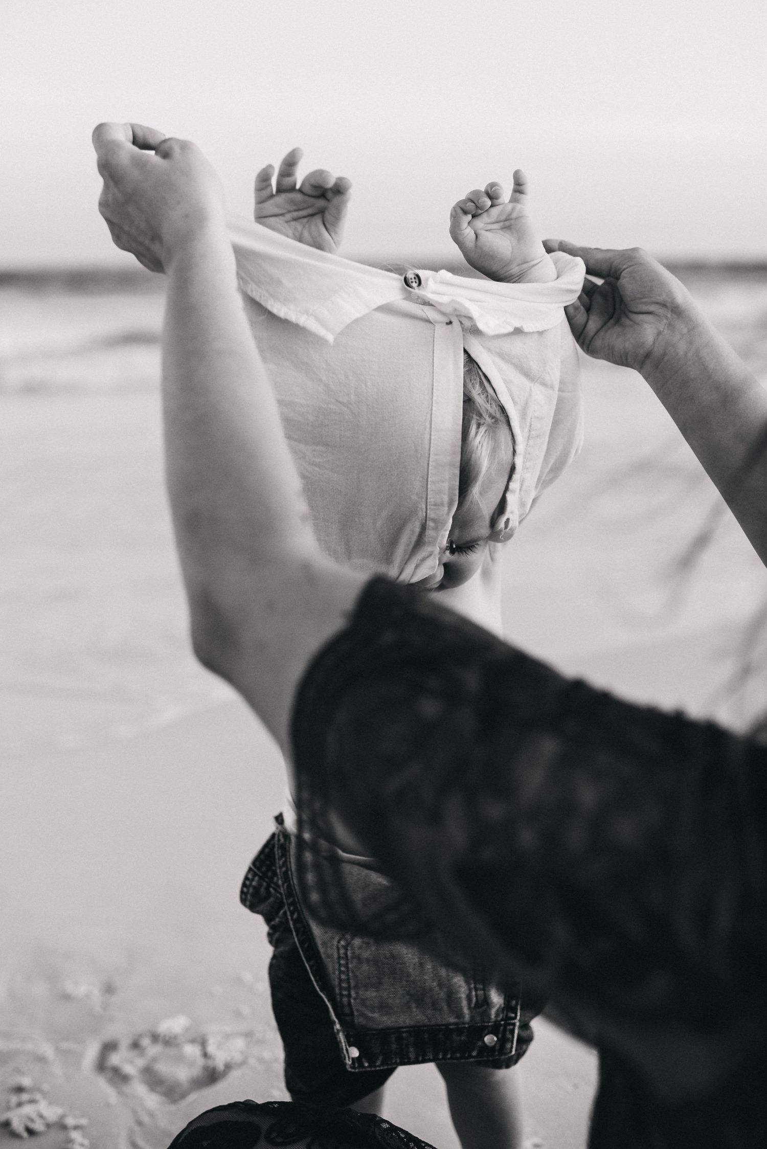 Santa Rosa family photographer captures candid moments on the beach during sunset hour. Moody natural candid portrait of child at ocean.