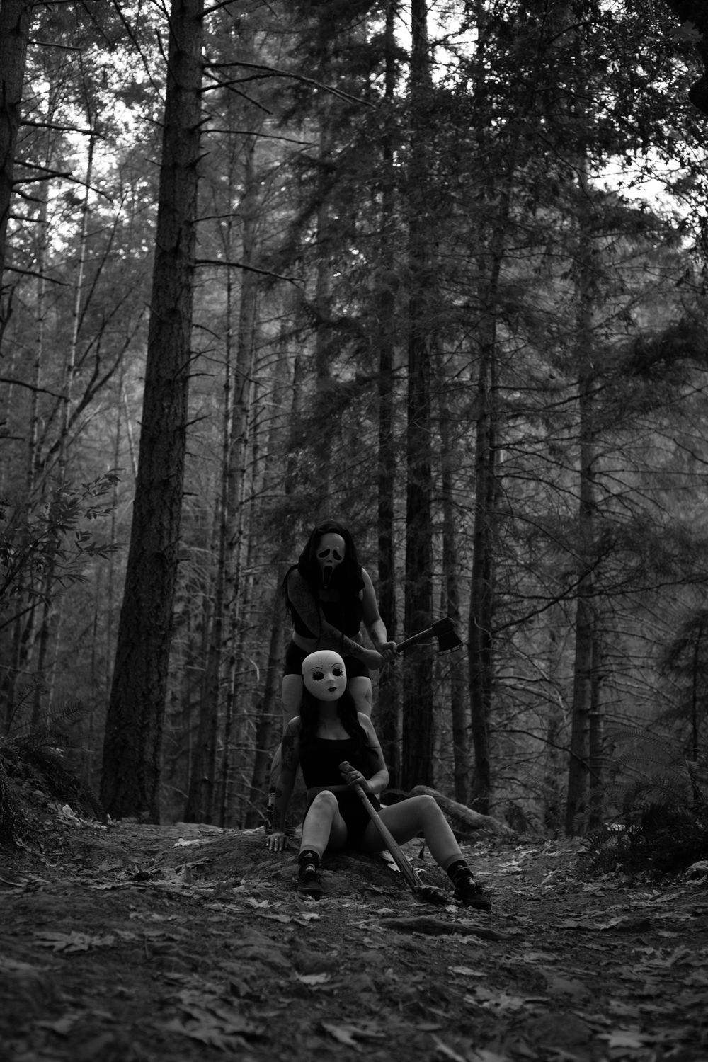 Mysterious figures pose dramatically on a dark forest trail.