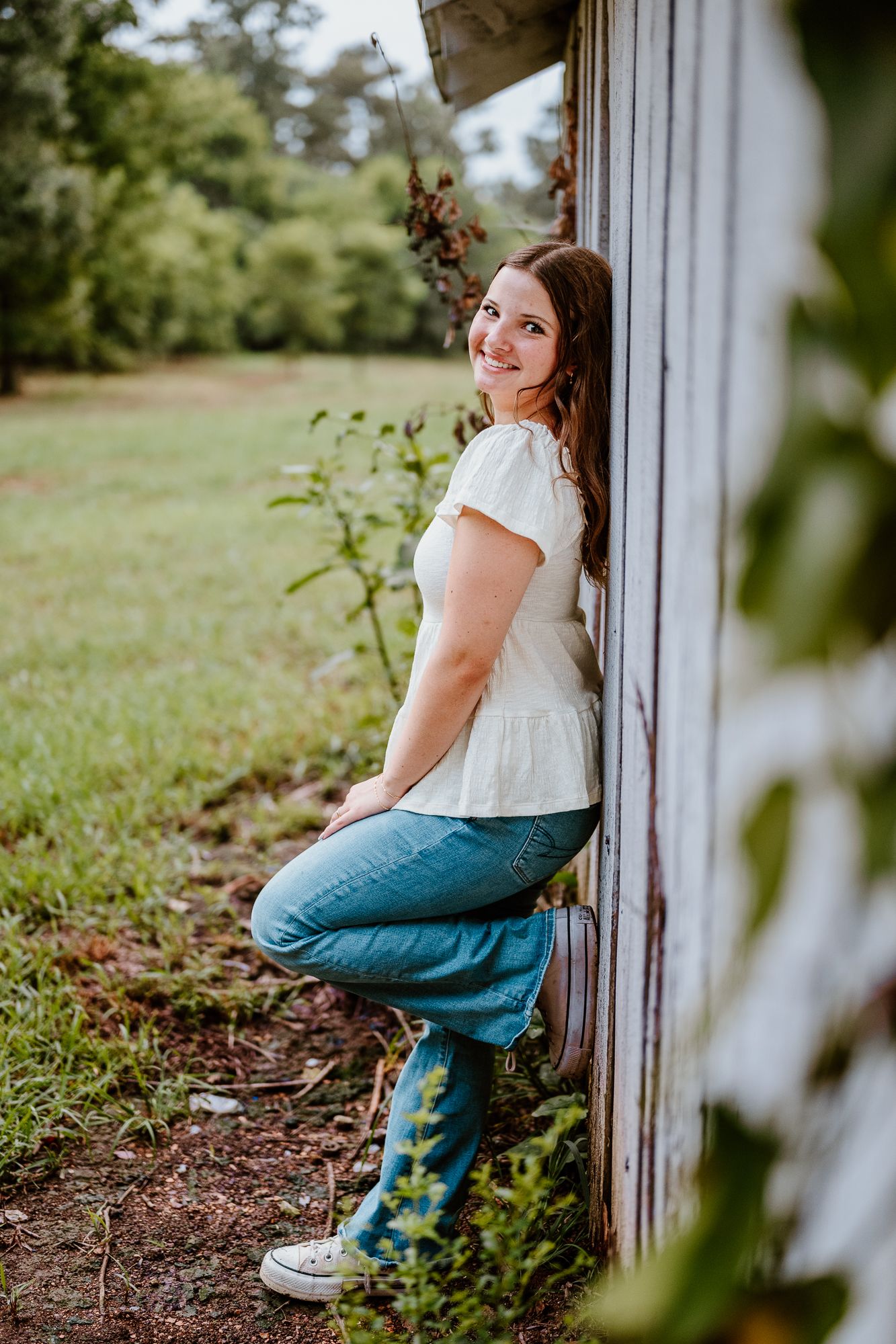 A sequence of casual portraits showing someone in jeans and white top sitting by a rustic wooden wall outdoors.