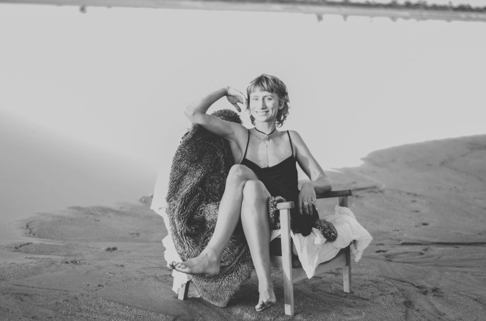 Vintage style black and white photo of person lounging on beach furniture.