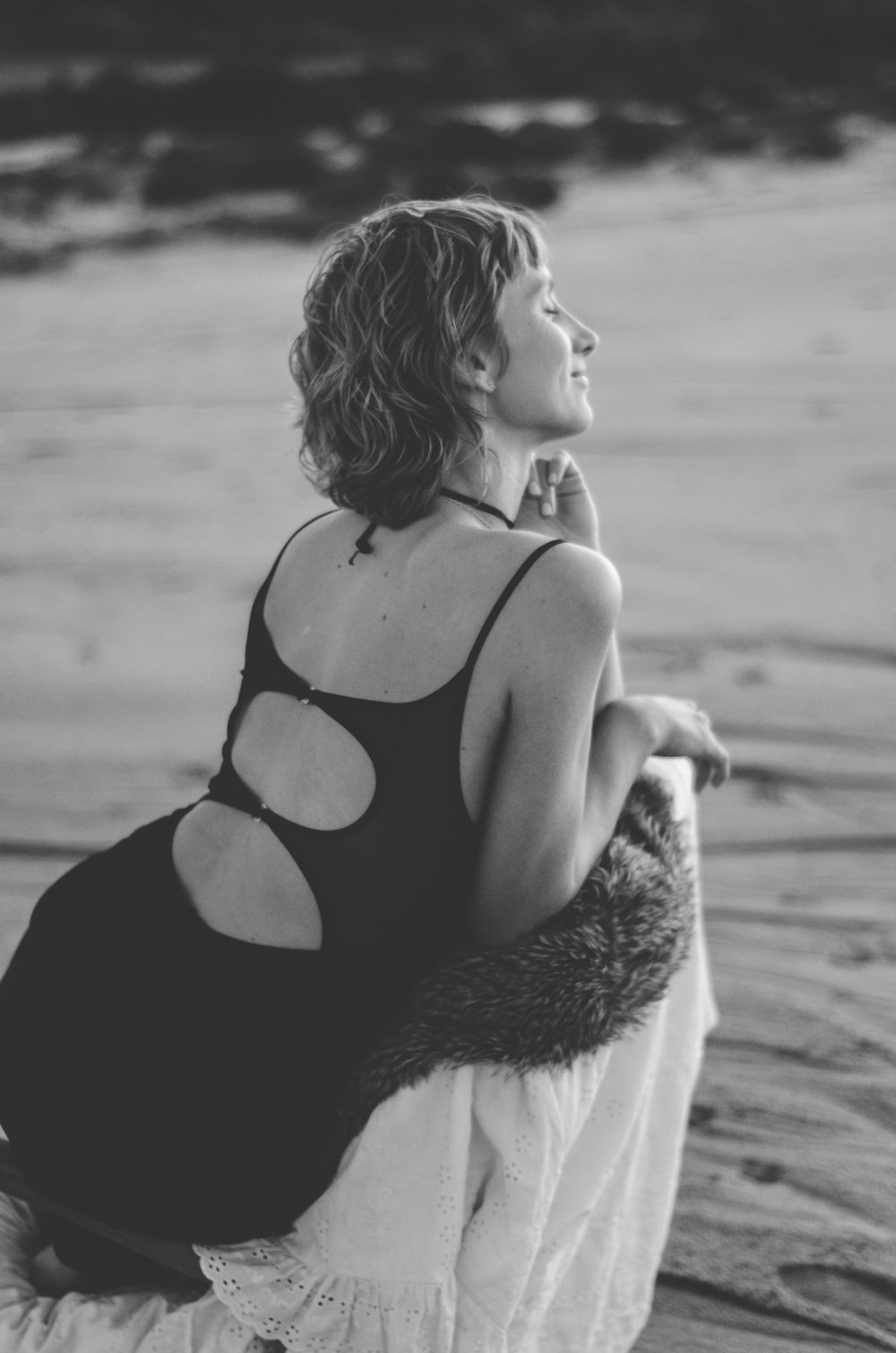 Black and white photo showing cutout dress detail on beach.