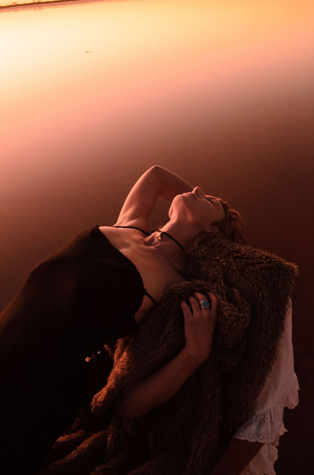 Artistic portrait in warm tones showing expressive dance movement against textured backdrop.