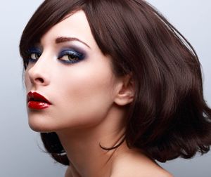 Glamour beauty portrait featuring red lips and smokey blue eye makeup.