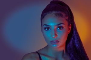 Dramatic beauty portrait with blue and orange lighting effects.