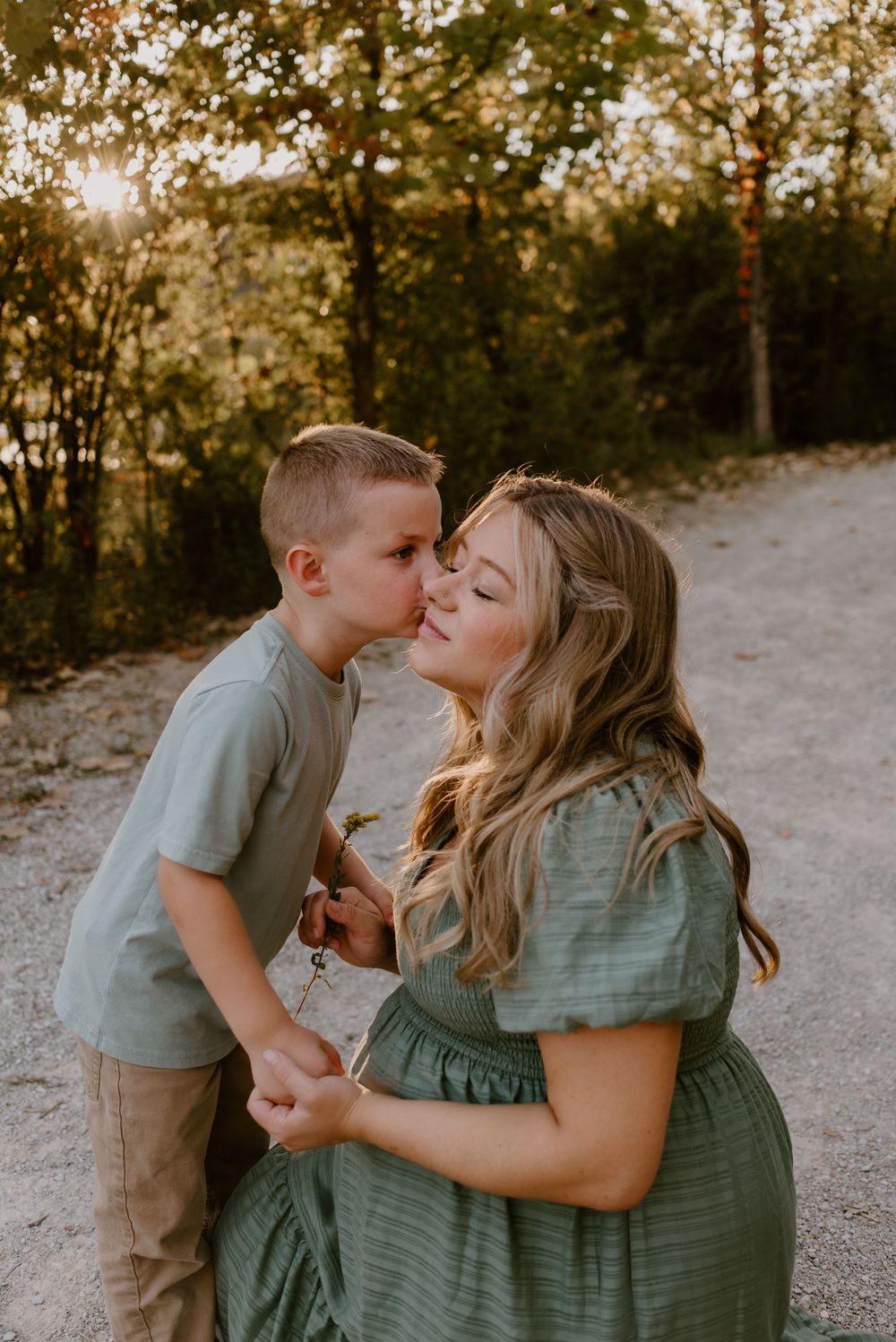 A sweet outdoor family photoshoot with sage green and neutral tones during golden hour.