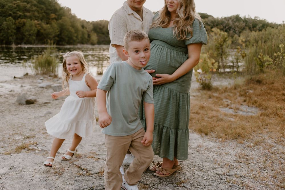 Candid family moments captured on a rocky path during sunset.