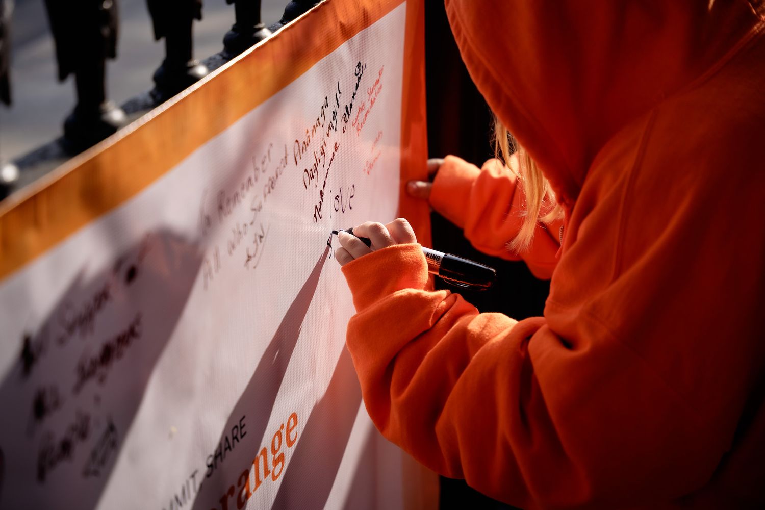 Little girl writing her wish on a white board to share her thoughts on Truth and Reconciliation Day.