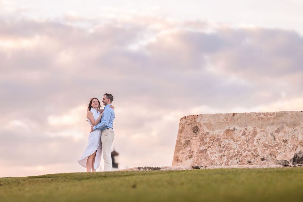 Wide view of couple on hill with historic fortress wall in Old San Juan Puerto Rico
