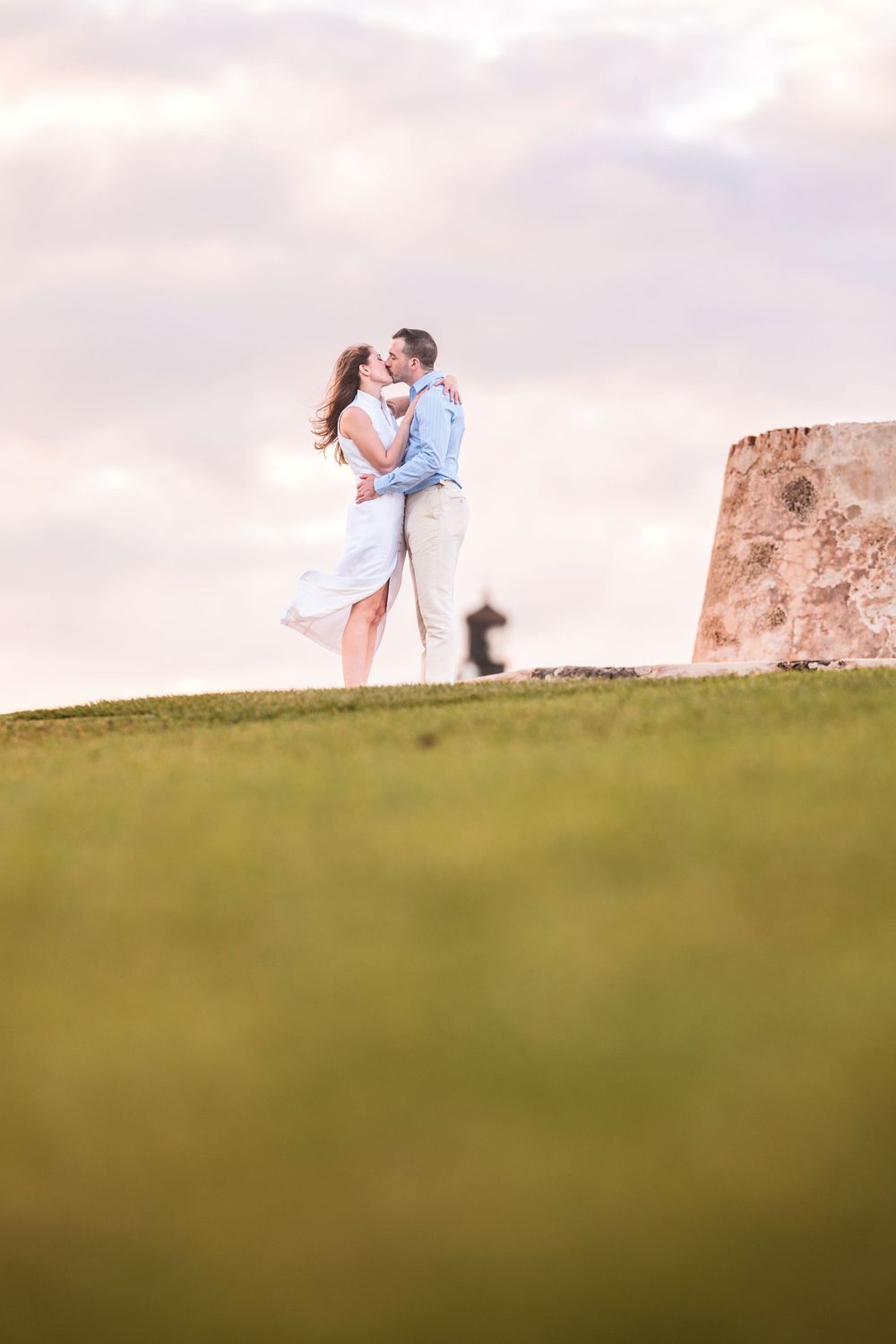 Couple standing on grassy hill overlooking ocean in Old San Juan Puerto Rico