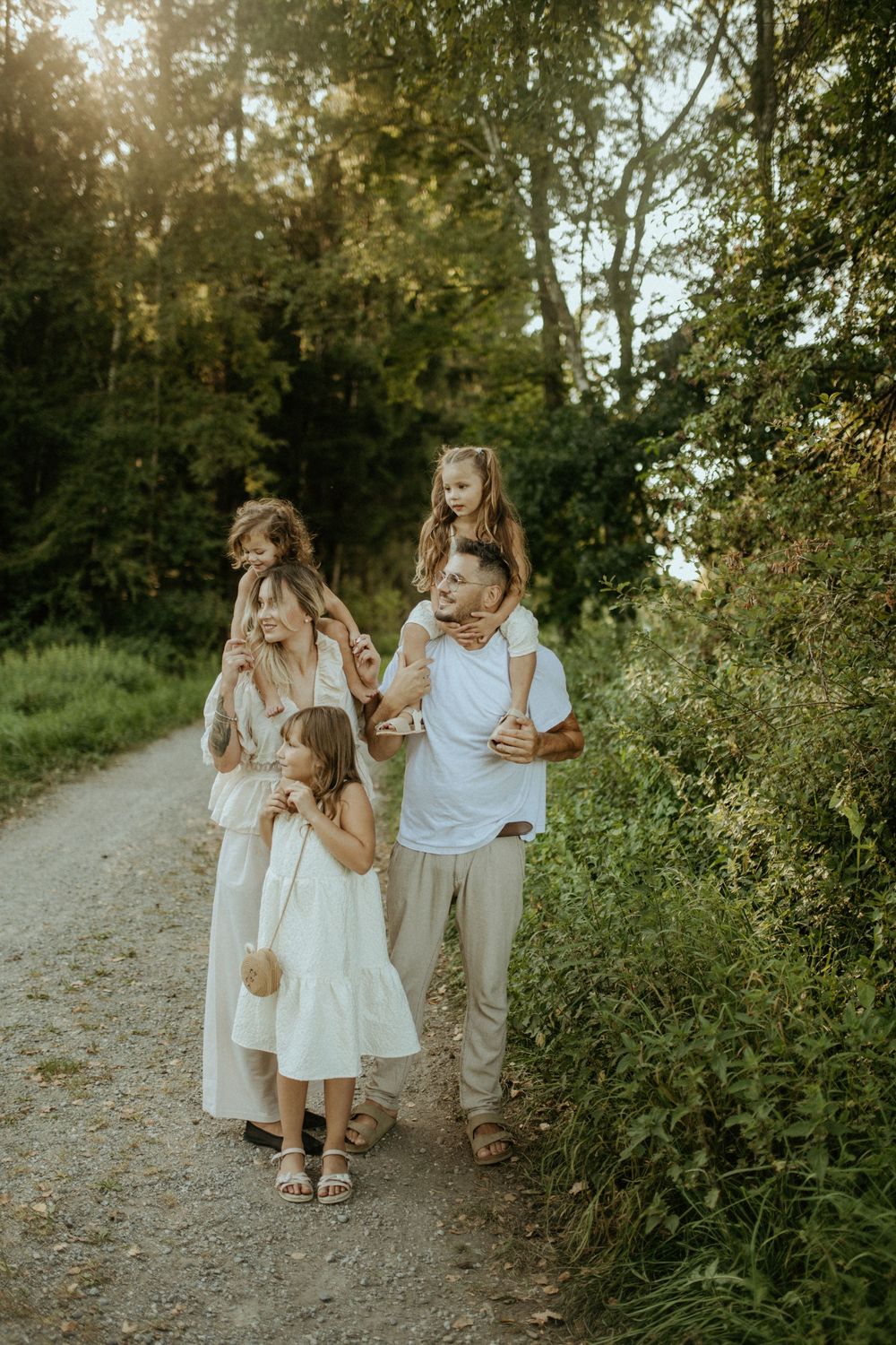 A family walking together on a nature path surrounded by lush greenery.