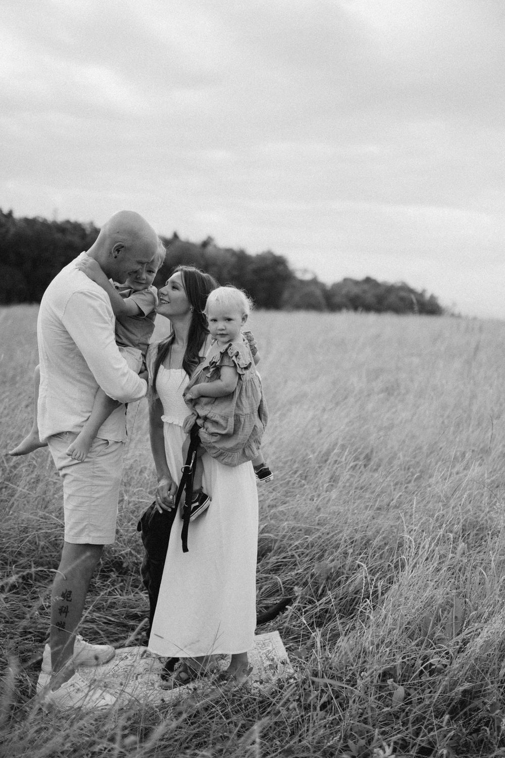 Sweet family moments photographed in tall grass during golden hour.