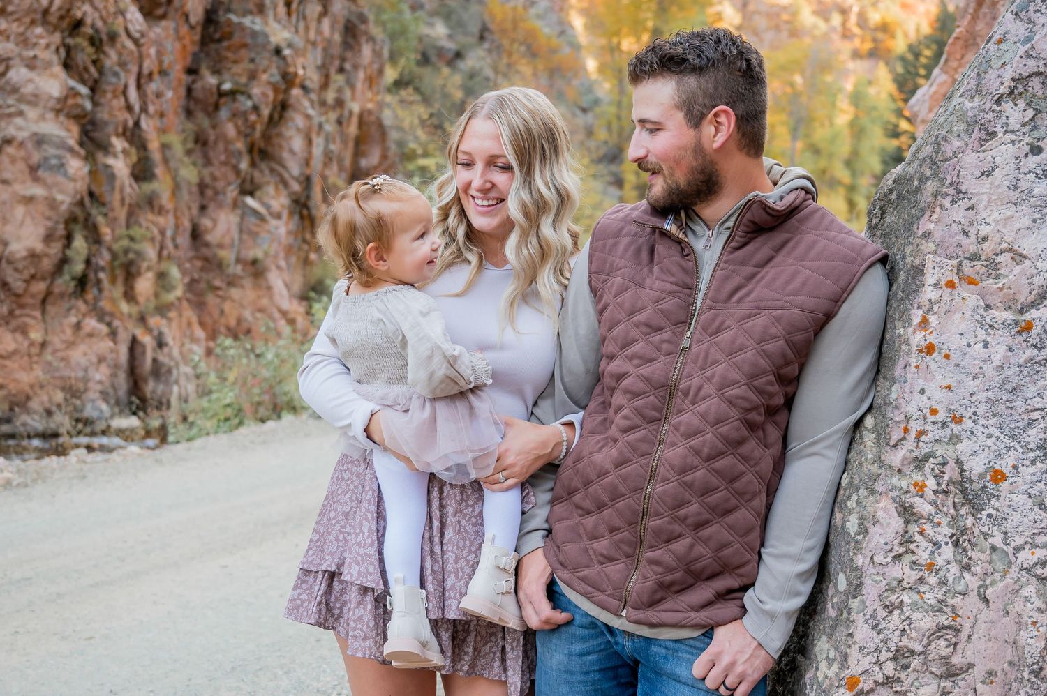 Family portrait session in front of rocky mountain cliffs during sunset.