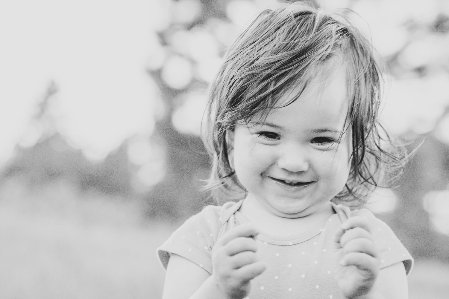 Black and white close-up portrait of a smiling child.