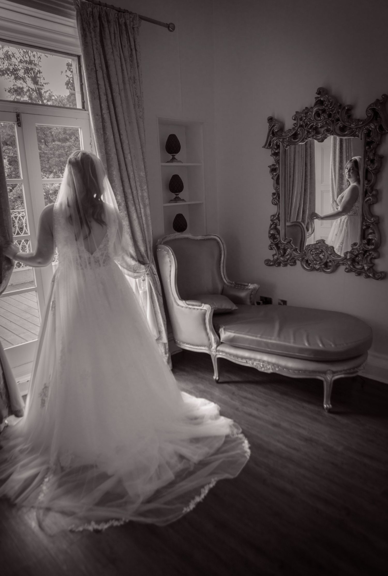 Black and white sequence of a bride's wedding dress flowing elegantly as she twirls in an ornate room.