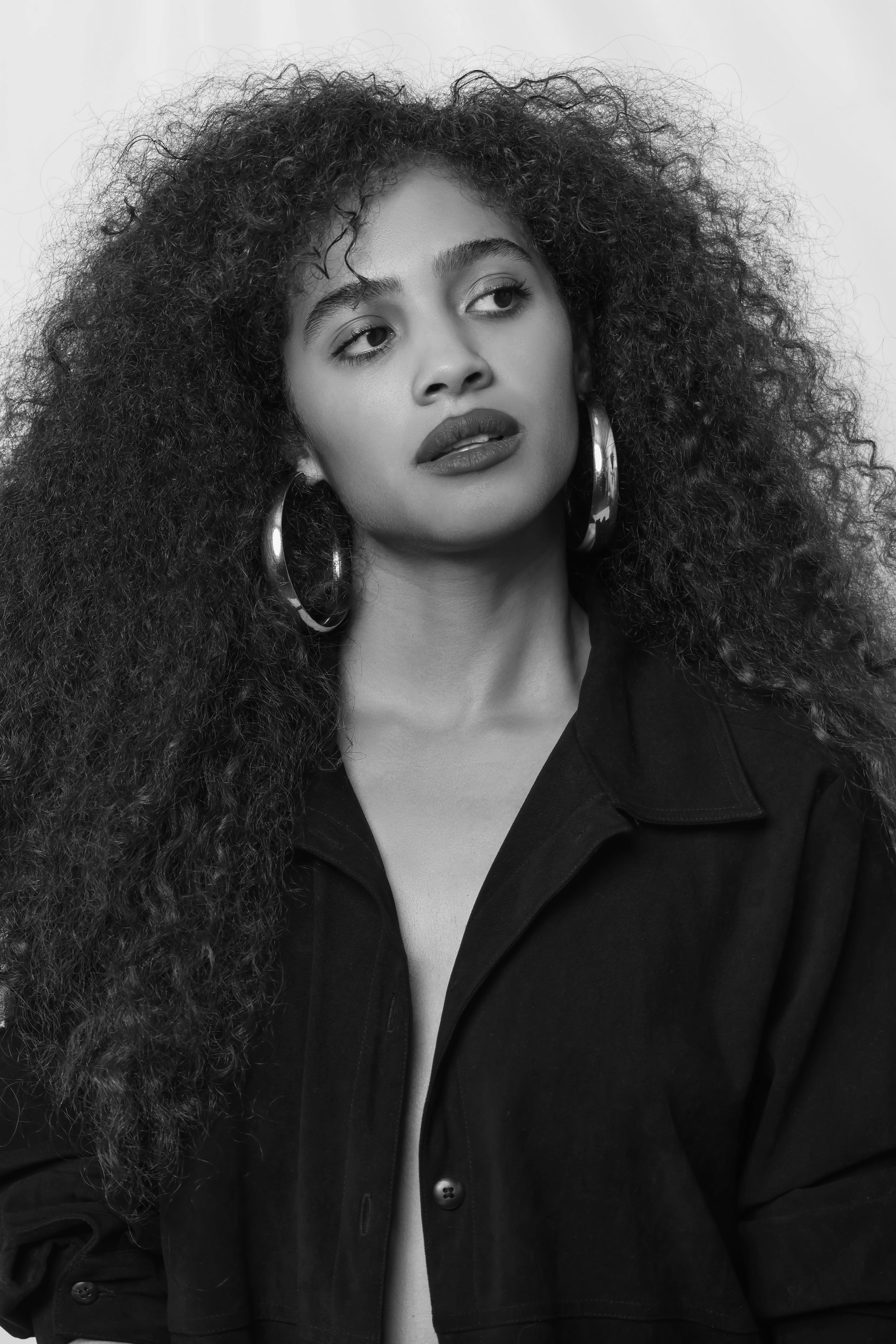 Studio fashion portraits with bold red lips and statement earrings.