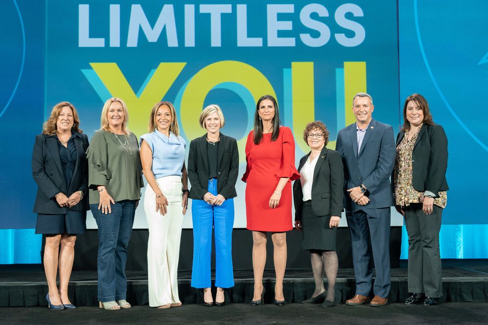 Large conference stage with blue lighting and "LIMITLESS" text displayed prominently above.