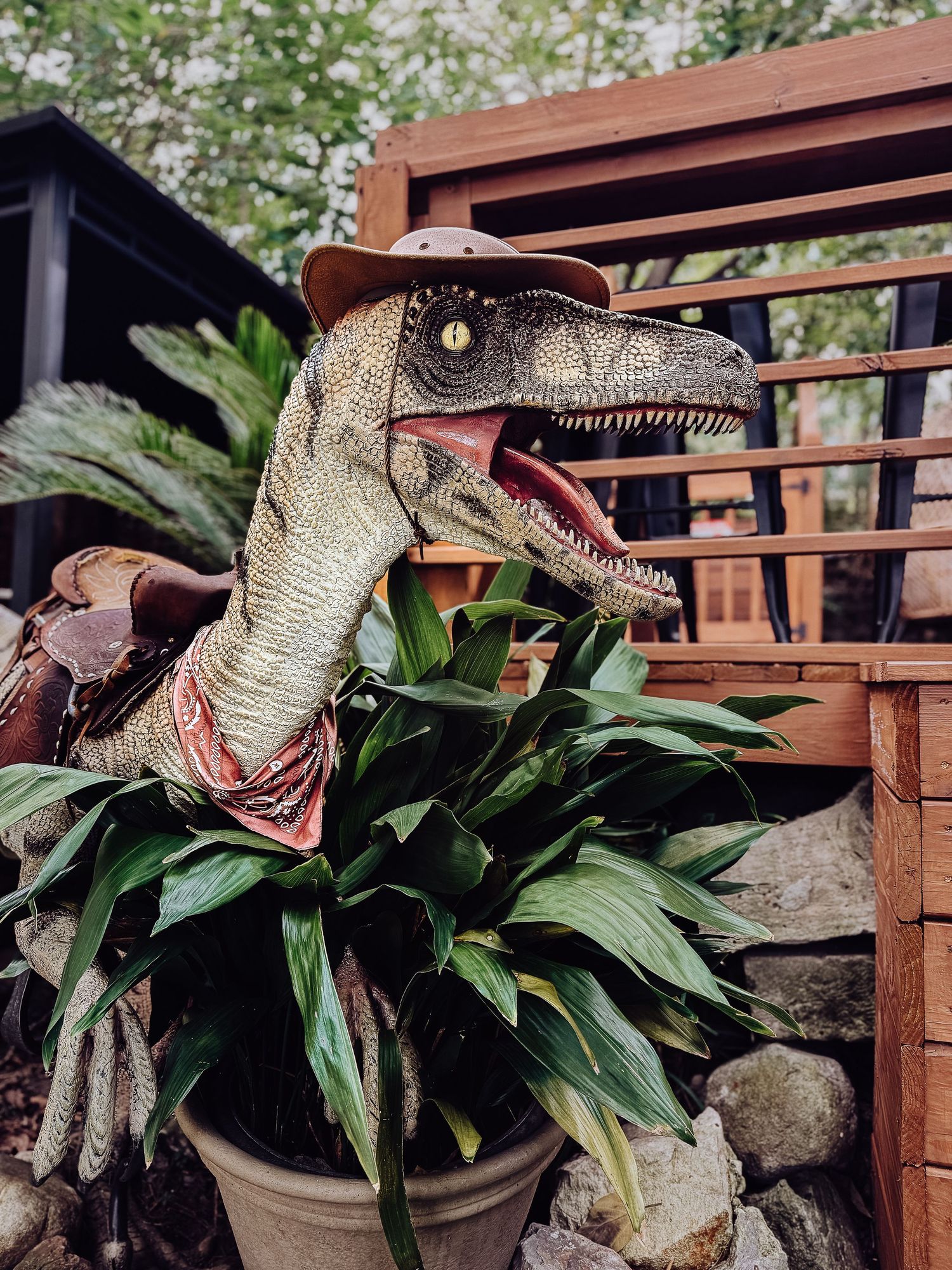 A series of velociraptor dinosaur model photos showing the creature's head with open jaws among tropical foliage.
