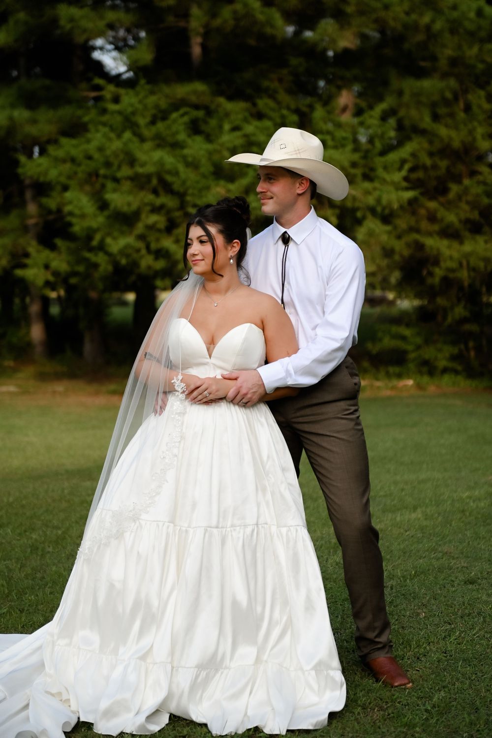 A romantic wedding photoshoot sequence showing a couple embracing in a grassy outdoor setting.