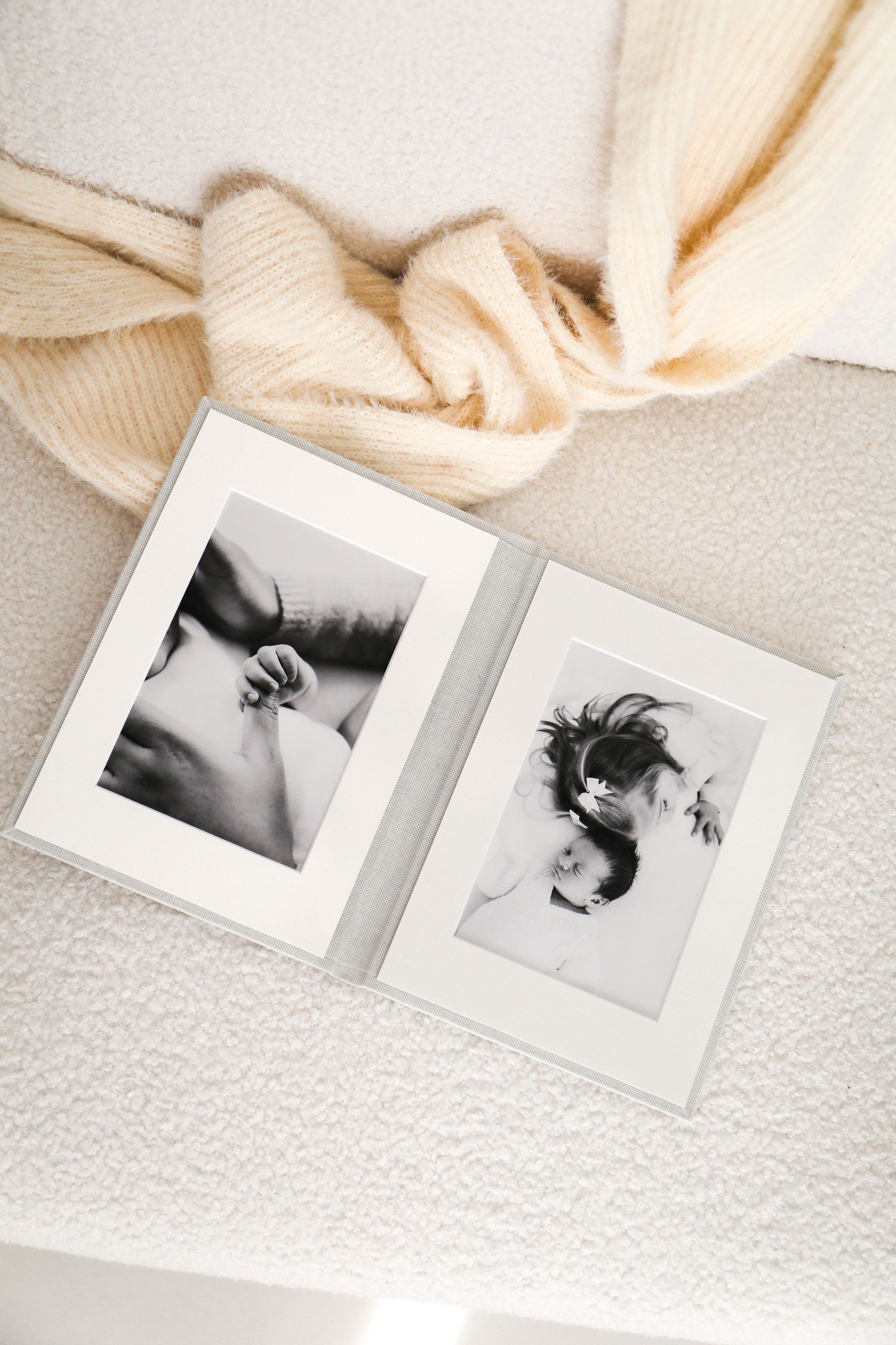 Black and white photo album pages with artistic portrait prints laid out on white textured surface. Nottingham family Photographer