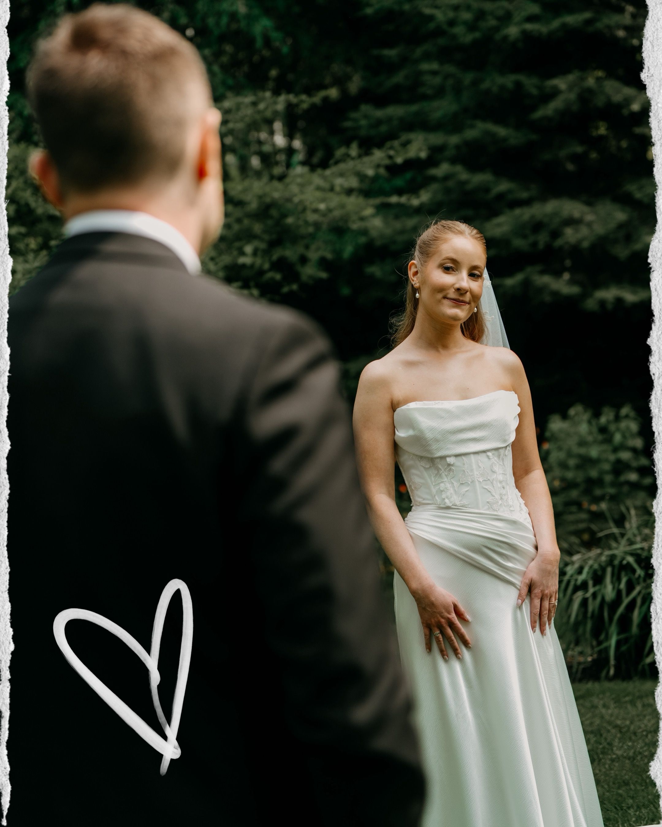 Wedding couple shares a romantic moment in a lush green forest setting.