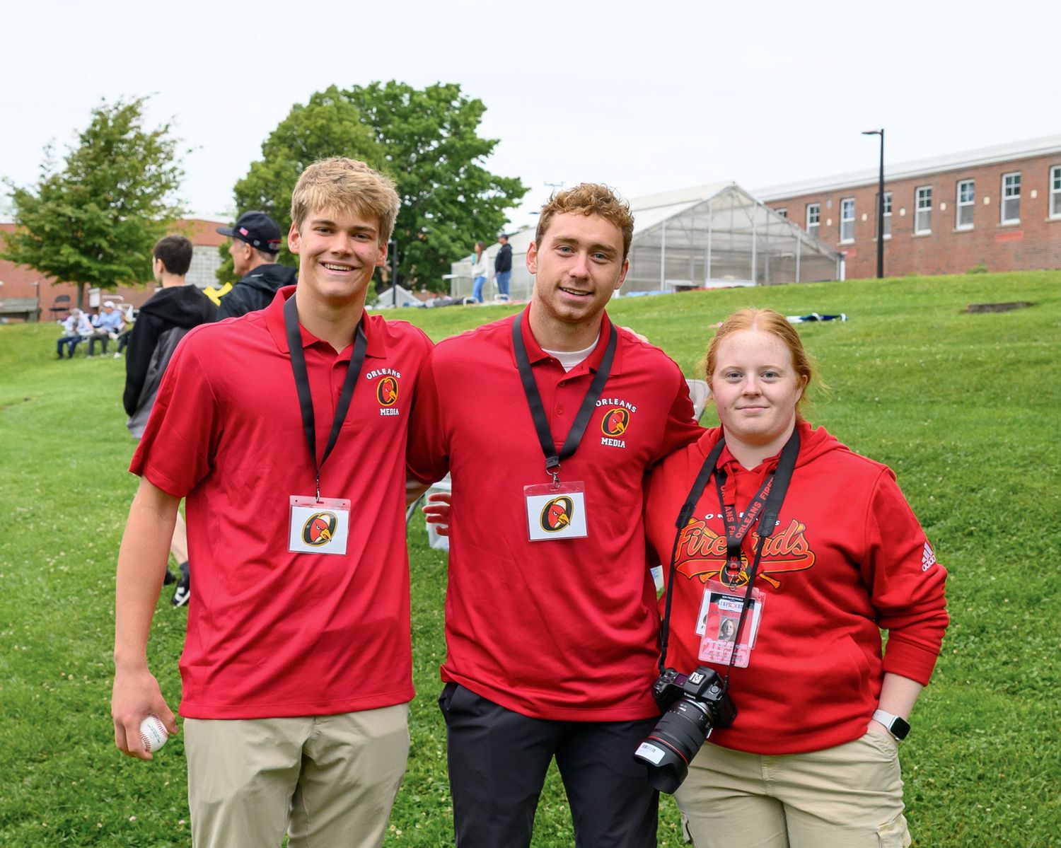 Campbell Mulligan stands with two other interns for the Orleans Firebirds baseball team.