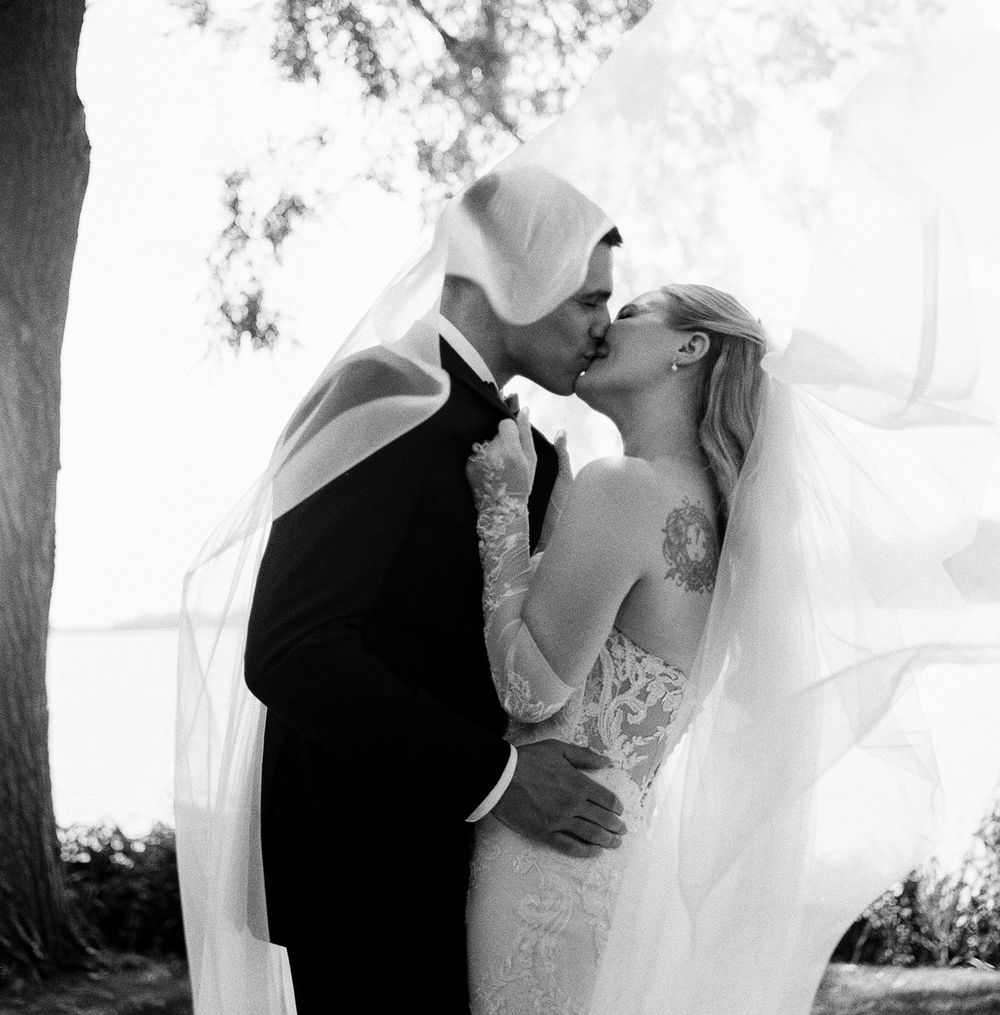 Romantic black and white wedding photos showing intimate moments under a veil.