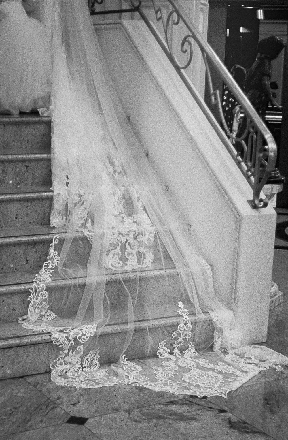 A series of black and white photographs showing the detailed lace trim on a wedding dress veil trailing on the ground.