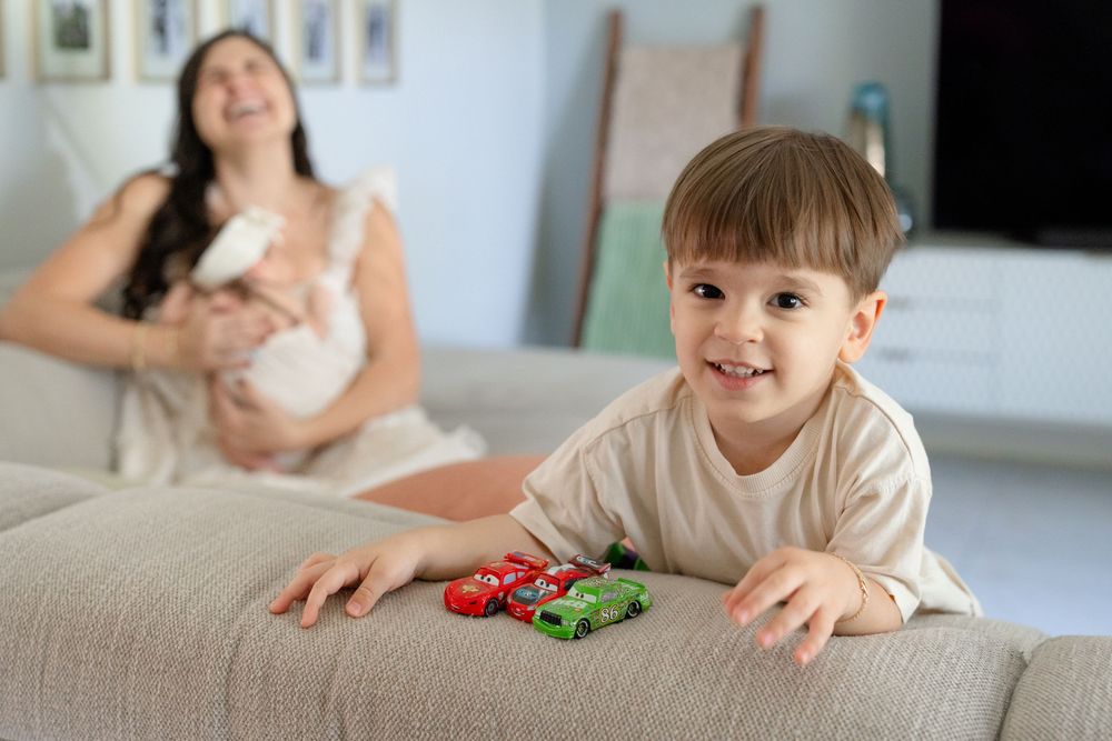 Child playing with toys while sitting on light colored couch.