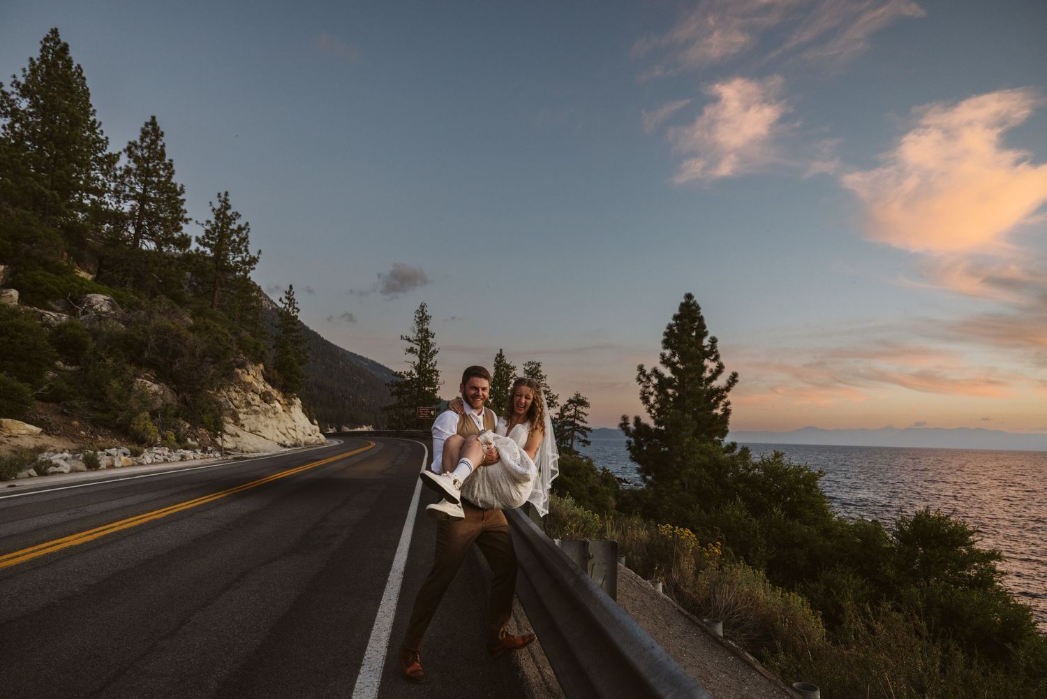 Scenic mountain road winding along a coastline during golden hour sunset.