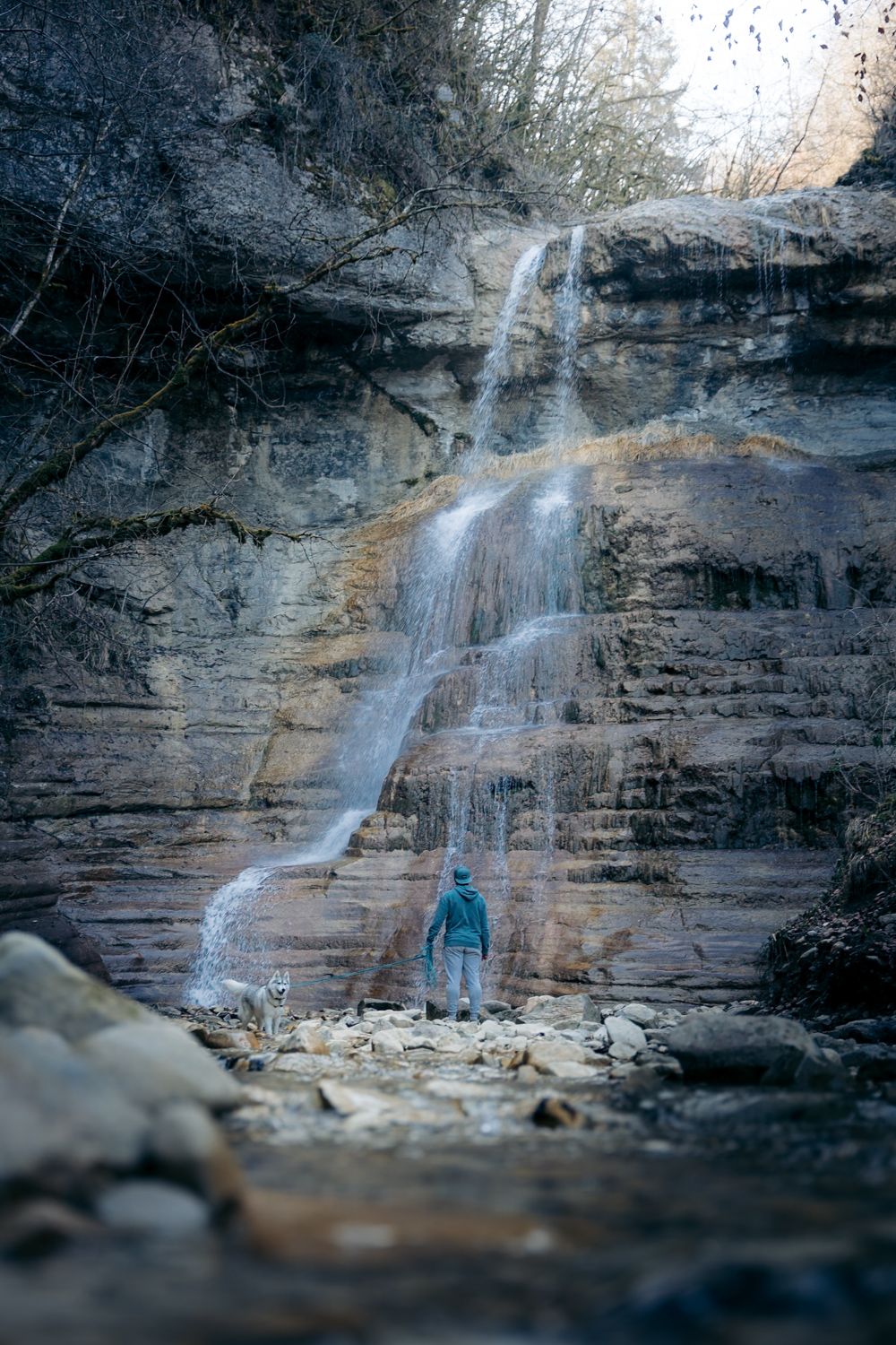 Cascade du Pichut à Apremont avec une homme et son chien en dessous de la cascade