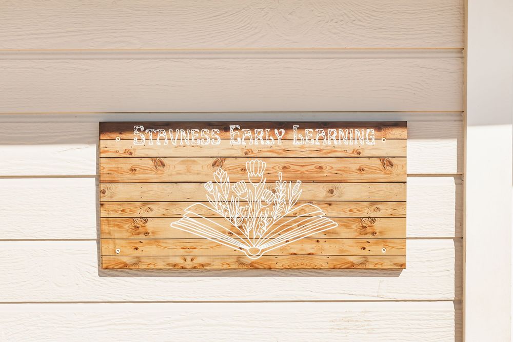 Rustic wooden sign with white text mounted on a white wall displays a message about family traditions.