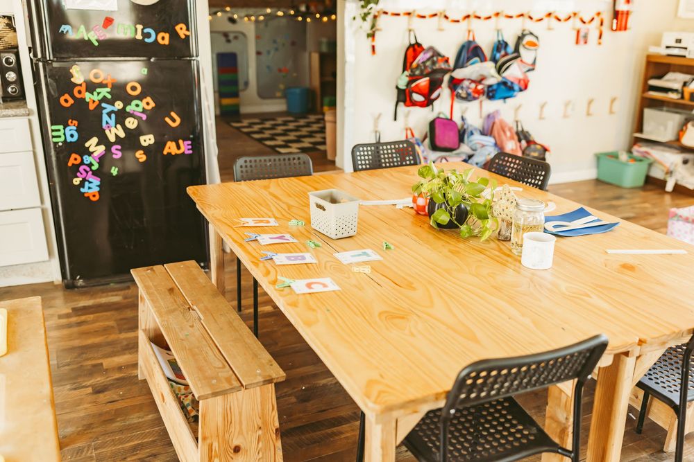 Cozy cafe interior with wooden tables, string lights, and festive red decorations along the ceiling.