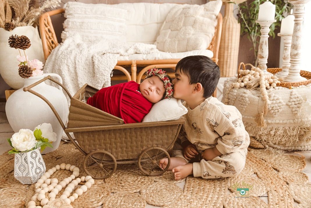 A child plays with a white fluffy dog on a cozy rug surrounded by holiday decor and pillows.