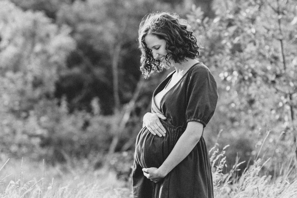 Intimate black and white portrait of parent and child sharing a moment in nature.