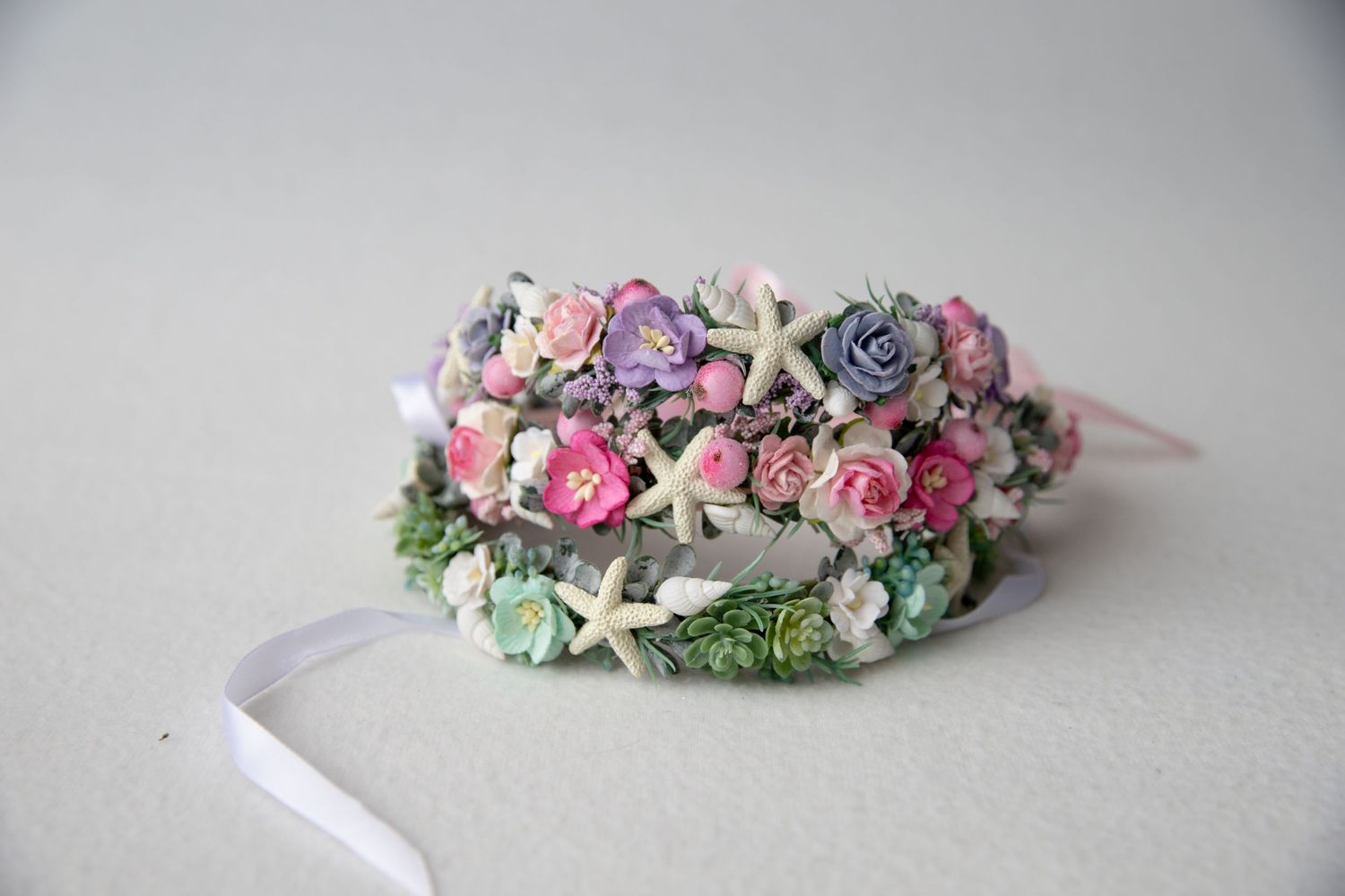 Delicate floral crown with pink roses, starfish and mixed blooms with white ribbon.
