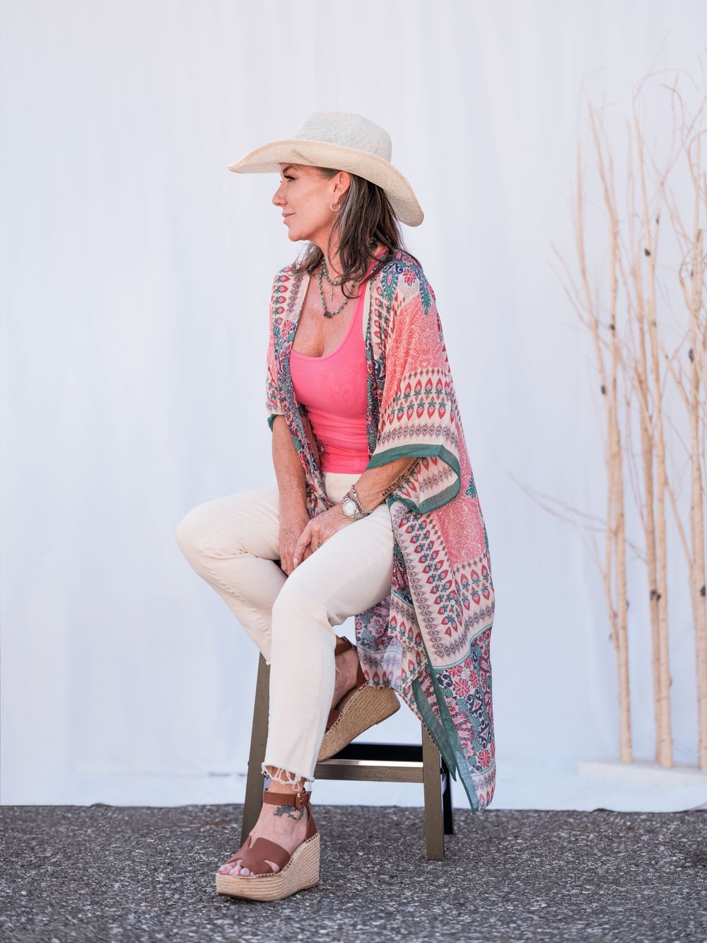 Side view of western-inspired outfit featuring flowing kimono, pink top and platform sandals.