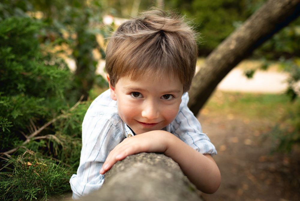 Young child poses playfully in outdoor portrait session.