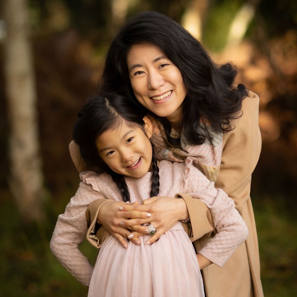 Mother and daughter share loving embraces in a natural outdoor setting with warm lighting.