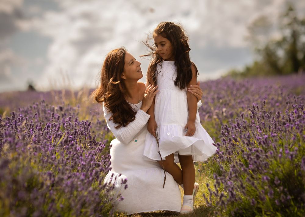 Two people in white dresses dancing in a purple lavender field.