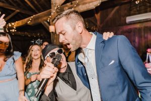 Two people share a fun moment while partying at a rustic indoor venue with twinkle lights on the ceiling.