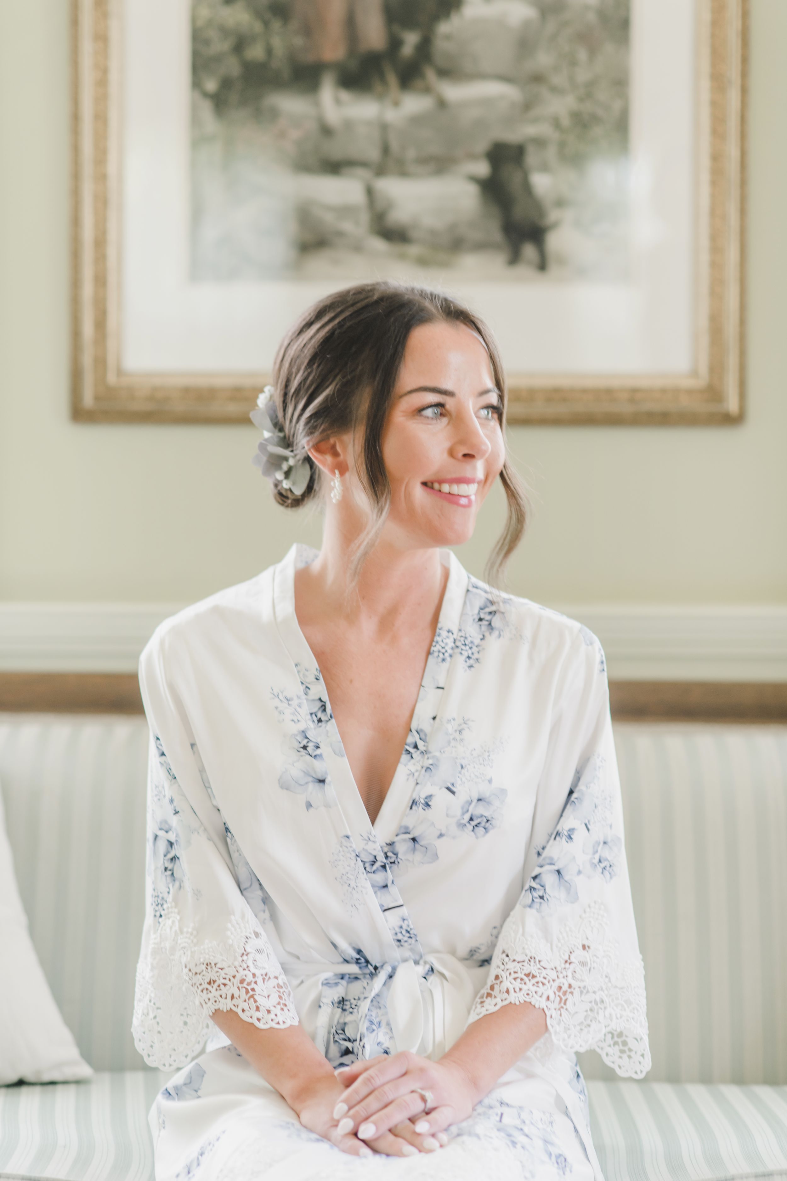 Elegant white and blue floral robe with lace trim details worn while sitting on a white couch.